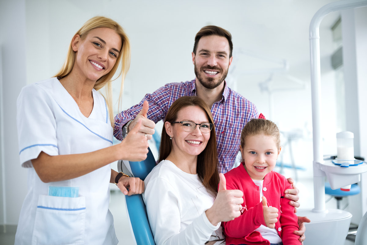 Satisfied family with a smiling young female dentist in a dental office