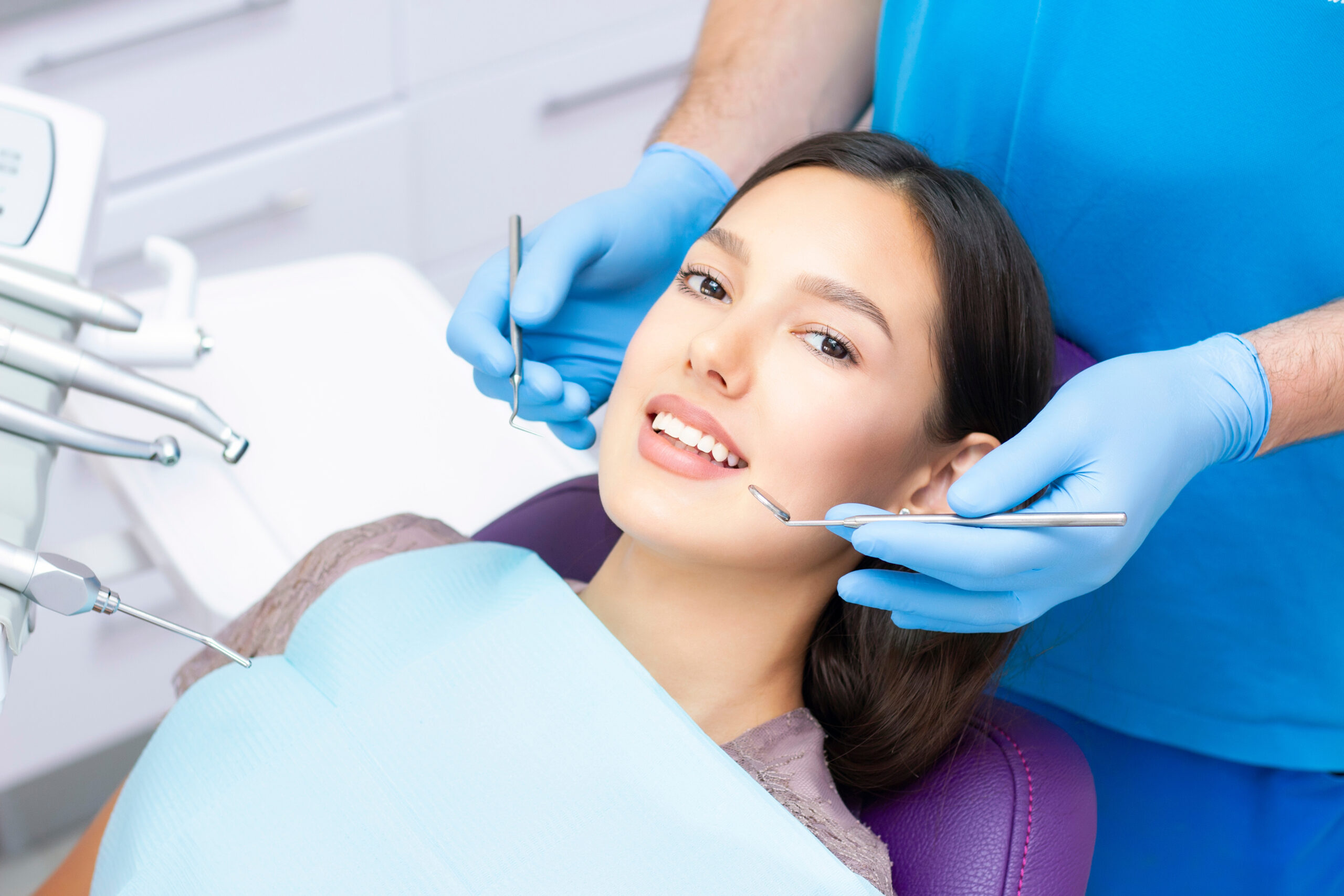 Young Female patient with pretty smile examining dental inspection at dentist clinic. Healthy teeth and medicine, stomatology concept